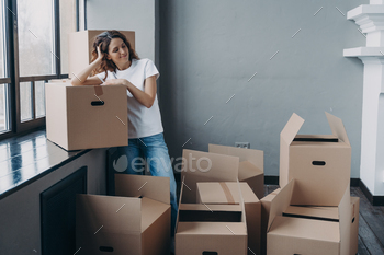 nt, standing near window sill with boxes on floor. Female dreaming about happy future in own home. First realty, mortgage concept.