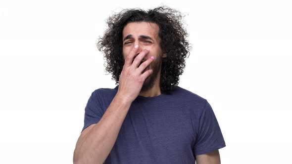 Portrait of Muscular Sleepy Guy with Insomnia Yawning and Covering Open Mouth with Hand Over White