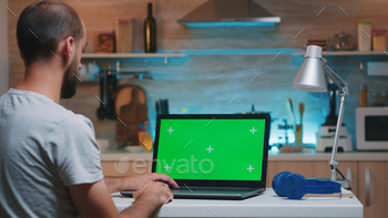 Businessman looking at green screen monitor