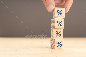 . Hand picking a wooden block with percentage symbol icon. Copy space