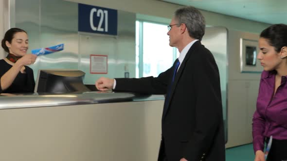 Airport passengers check in at ticket counter