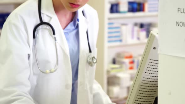 Pharmacist making prescription record on computer