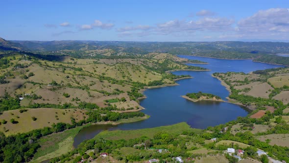 Aerial view of beautiful idyllic landscape with river and Bao Dam during sunny day on Dominican Repu