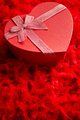 Heart shaped boxed gift, placed on red feathers background - PhotoDune Item for Sale