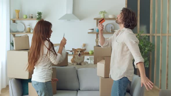 Happy Couple Feeling Satisfaction of Shopping Online with a Credit Card at Home.