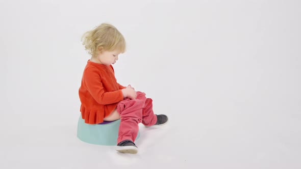 Cranky Tired Sleepy Toddler Girl Sitting on Potty Telling Parents to Bring Toys