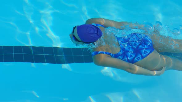 Young female swimmer swimming inside pool 4k