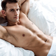 sexy young man in underwear lying on bed and looking at camera Stock Photo  by LightFieldStudios