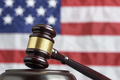 Close up of wooden judge gavel. American flag in background - PhotoDune Item for Sale