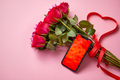 Pink roses bouquet with hart shaped bow and mobile phone with copy space screen - PhotoDune Item for Sale