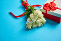 Bouquet of white roses with red bow on blue background. Boxed gift on side - PhotoDune Item for Sale