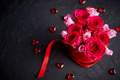 Pink roses bouquet packed in red box and placed on black stone background - PhotoDune Item for Sale
