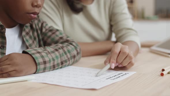 Unrecognizable Mother Helping Kid with Test