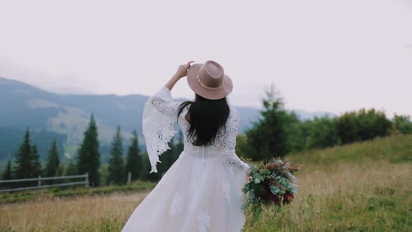 Backside view of a woman in wedding dress among nature