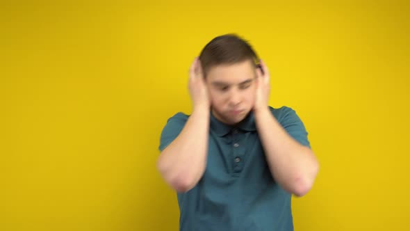 Young Man Dancing with Headphones on a Yellow Background. A Man in a Green Polo Is Listening To