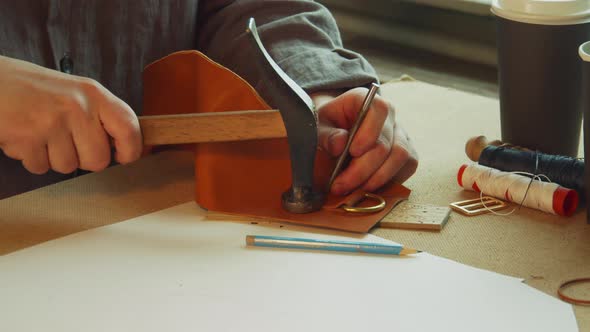 With a Core and Hammer, the Tanner Punches Holes for Sewing an Exclusive Bag Made of Genuine Leather