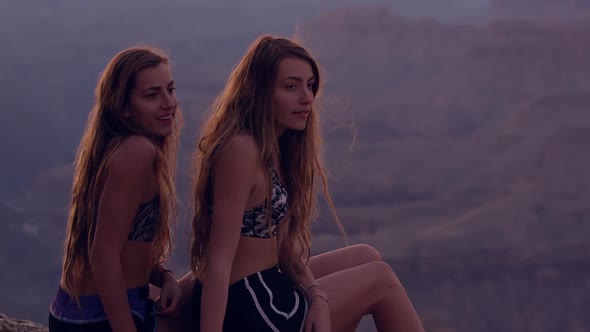 Teenage girls overlooking Grand Canyon at Dusk and leaving edge