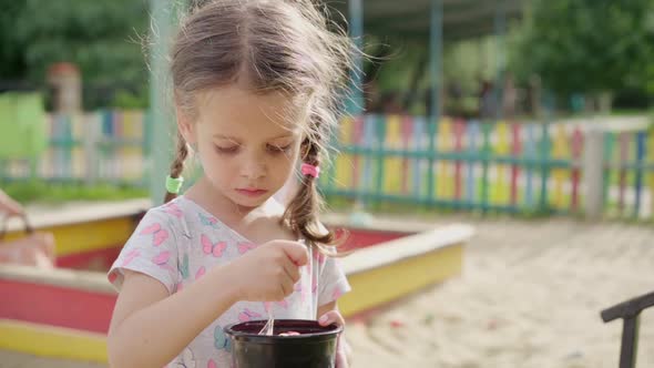 Little Girl Eat Ice Cream Spoon Outdoor Playground Plastic Plate Summer Day Slow Motion