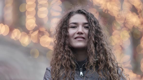 Portrait of Young Charming Woman in City Decorated Festive Illumination at Christmas Vacation Snow