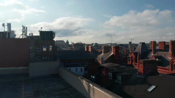 Backwards Descending Shot of Historic City Landing on Rooftop Car Park