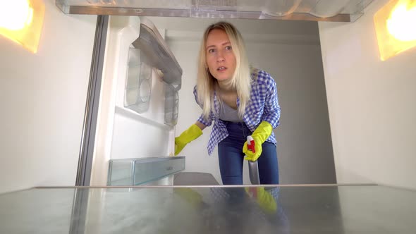 A woman looks inside the refrigerator and screams. Stress. cleaning.