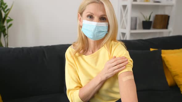 Senior Woman Showing Her Arm with Band Aid After Coronavirus Vaccine