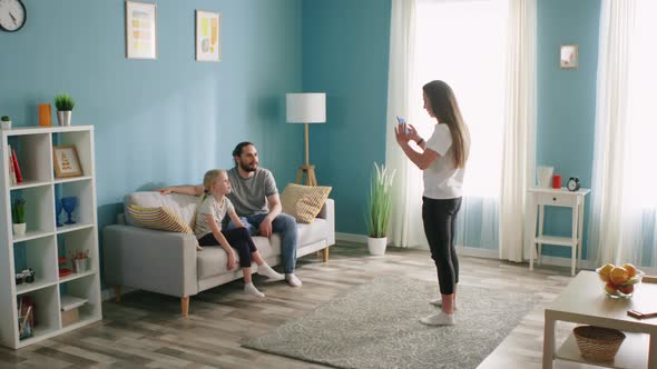 Couple and Small Girl Entertain in Living Room