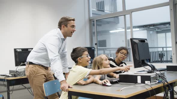 Teacher with Pupils Having Fun During Computer Science Lesson