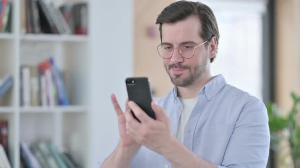 Portrait of Man in Glasses Using Smartphone