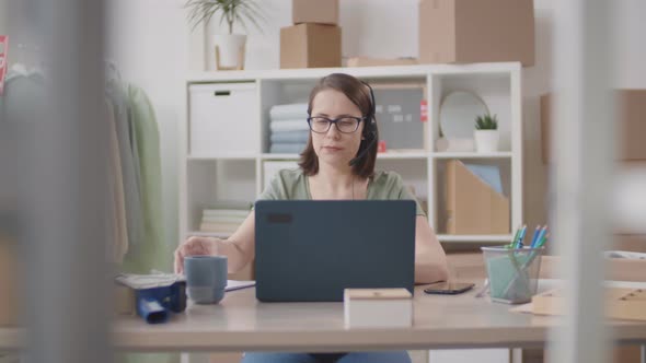 Internet Shop Worker Drinking Coffee while Using PC