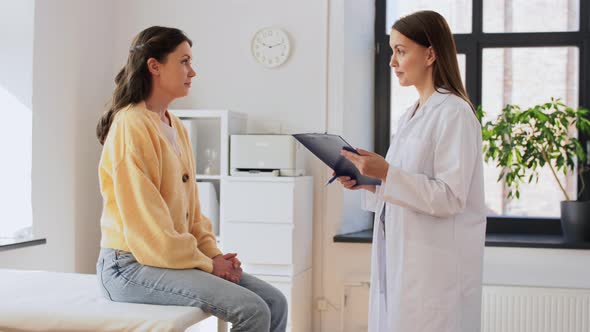 Doctor with Clipboard and Woman at Hospital