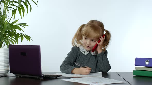 Funny Little Child Girl Boss Manager Emotionally Talking on Mobile Phone, Sitting at Computer Table