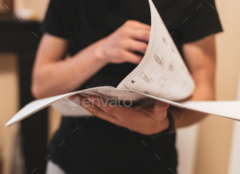 A young man holds an instruction paper in his hands.