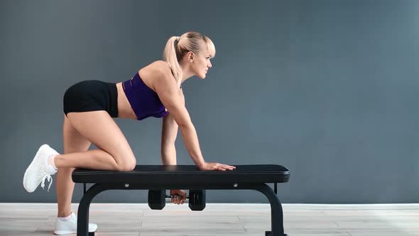 Muscular Woman Lifting Dumbbell During Back Workout at Gym