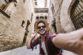 Happy male tourist taking selfie picture in front of Pont del Bisbe in Barcelona, Spain - PhotoDune Item for Sale