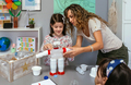 Teacher helping to girl make recycled toy robot with plastic packages - PhotoDune Item for Sale