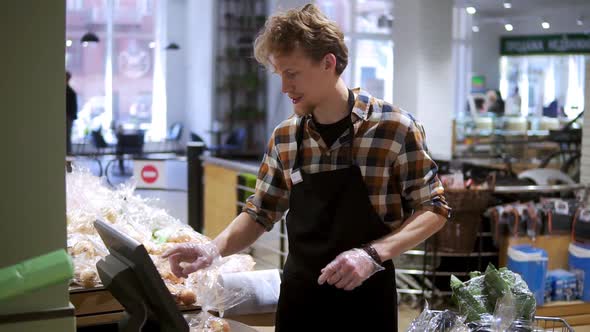 Caucasian Young Worker Arranging Potatos at Grocery Shop