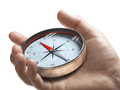 Hand holding a compass over white background. Strategic orientation or direction concept. - PhotoDune Item for Sale