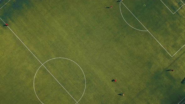 Aerial View of Football Team Practicing at Day on Soccer Field in Top View