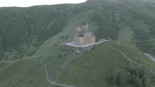 Stepantsminda, Georgia - May 8 2021: Aerial view of Gergeti Trinity Church, Tsminda Sameba. Kazbegi