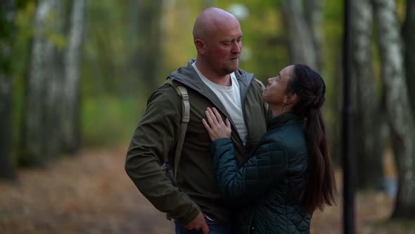 A Middle-aged Couple in Love, Smiling, a Woman with Dark Hair and a Bald Man Walk Through the Autumn