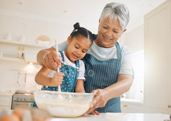ttle girl baking with her grandmother at home
