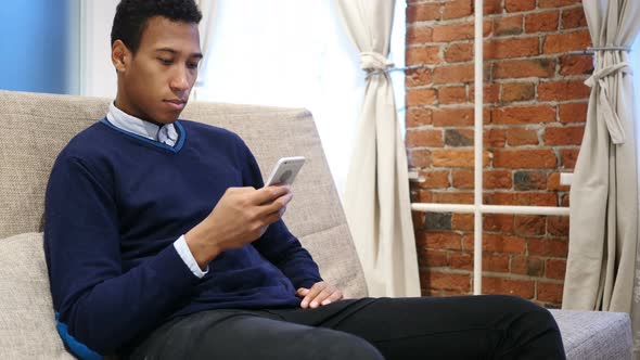 African Man Single Handed Browsing Online on Smartphone