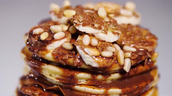 Pancakes with Chocolate Syrup, Nuts and Bananas. Stack of Whole Flapjack. Tasty Breakfast and