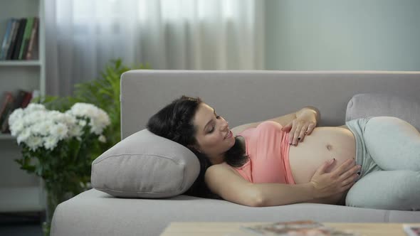 Young Future Mother Stroking Her Tummy and Communicating With Coming Newborn