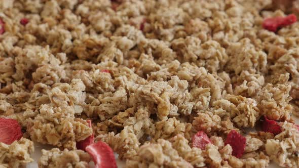Tilting over  muesli with strawberry flavour close-up 4K 2160p 30fps UltraHD footage - Healthy dehyd