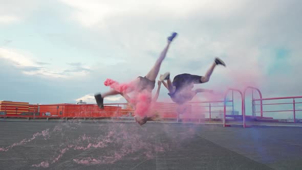 Slow Motion Young Peoples Holding Redblue Smoke Bombs in His Hands and Doing a Somersaults