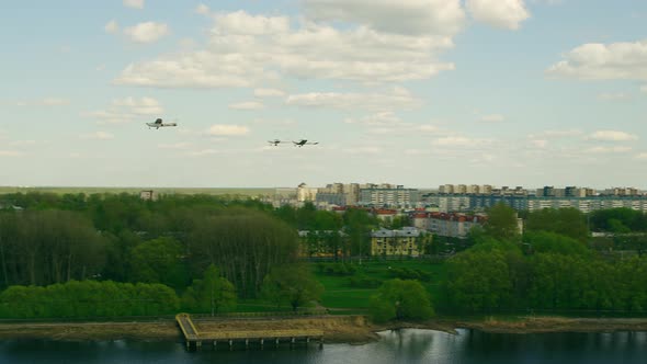 A Group of Three Propeller Planes Fly Over the Bridge and Fly in Different Directions on a Sunny