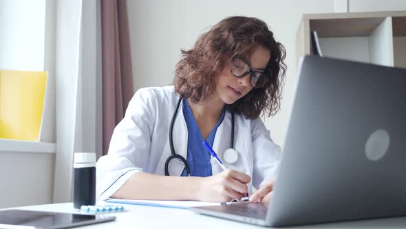 Latin Female Medical Assistant Video Calling Distant Patient on Laptop