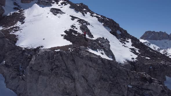 Anonymous traveler with drone on Picos de Europa mountains covered with snow